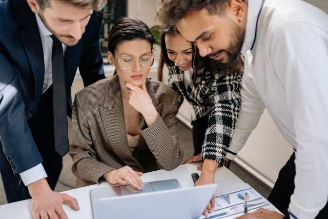 group-of-professionals-collaborating-around-laptop-in-office