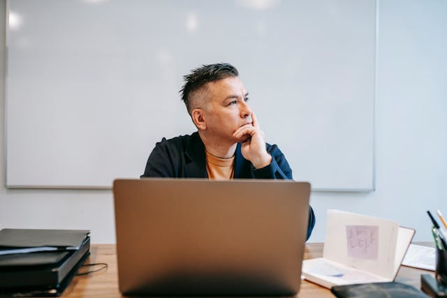 man-sitting-at-office-desk-thinking-about something